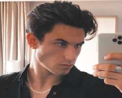 The star has piercings in his ears and also wears a chain on his neck.